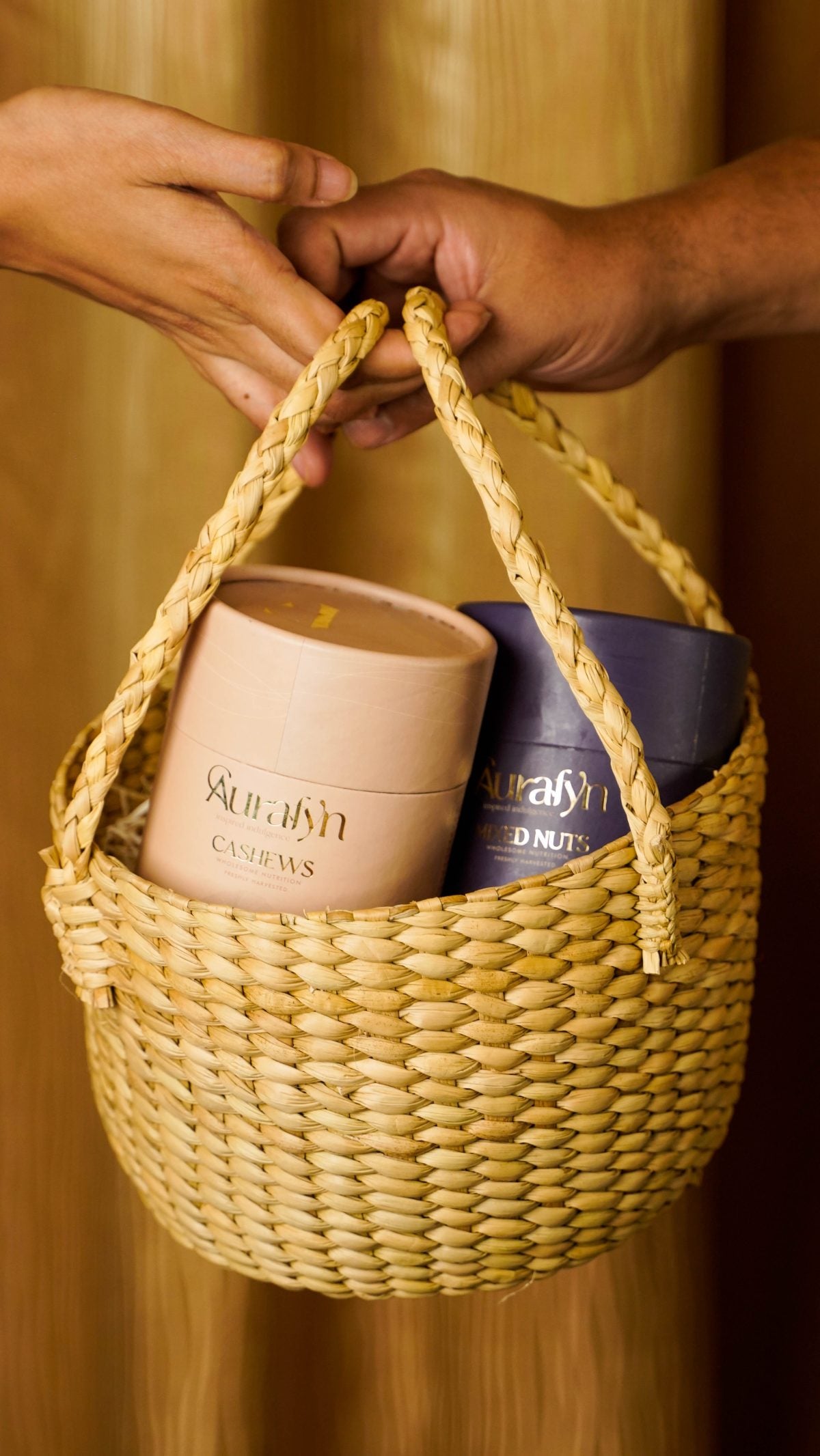 Two Aurafyn tubes in a woven basket, passed from one pair of hands to another